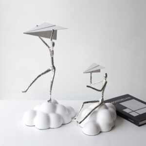 Simple and atmospheric abstract resin sculpture of a person playing with paper airplanes
